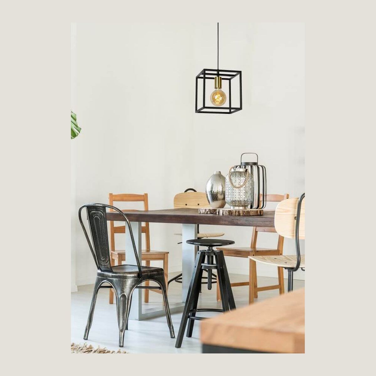 Suspension noire cubique suspendue au-dessus d'une table à manger en bois