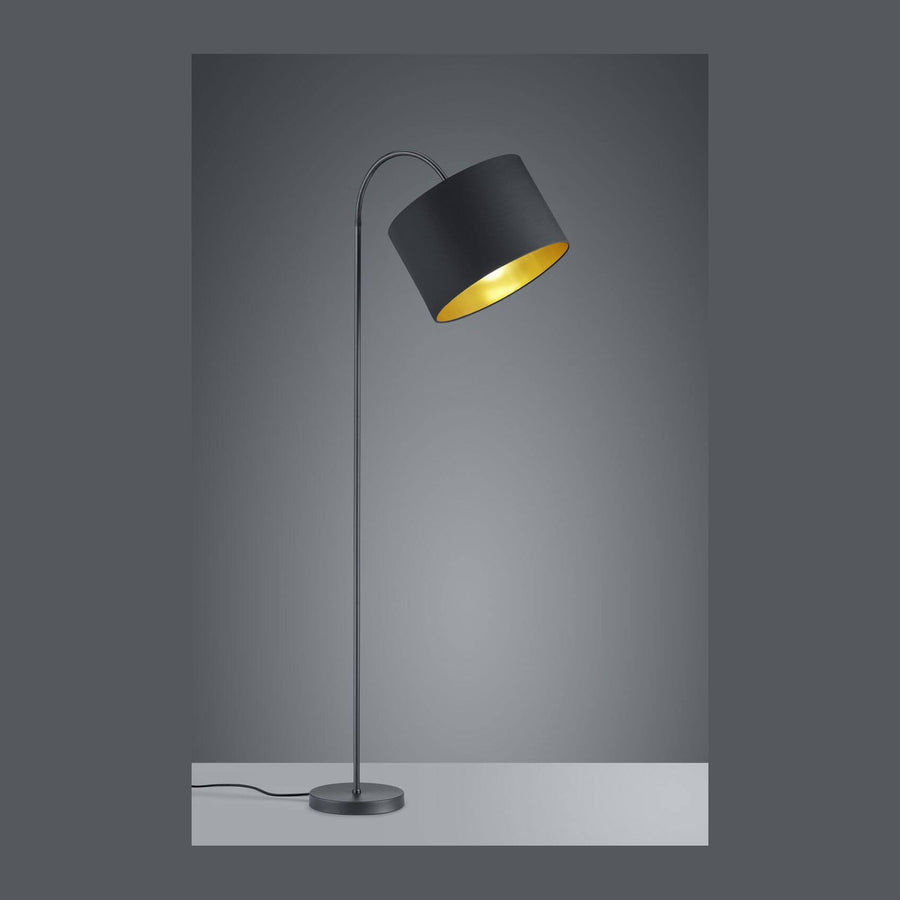 Lampadaire noir mat vu de face, abat-jour cylindrique à intérieur doré allumé.
