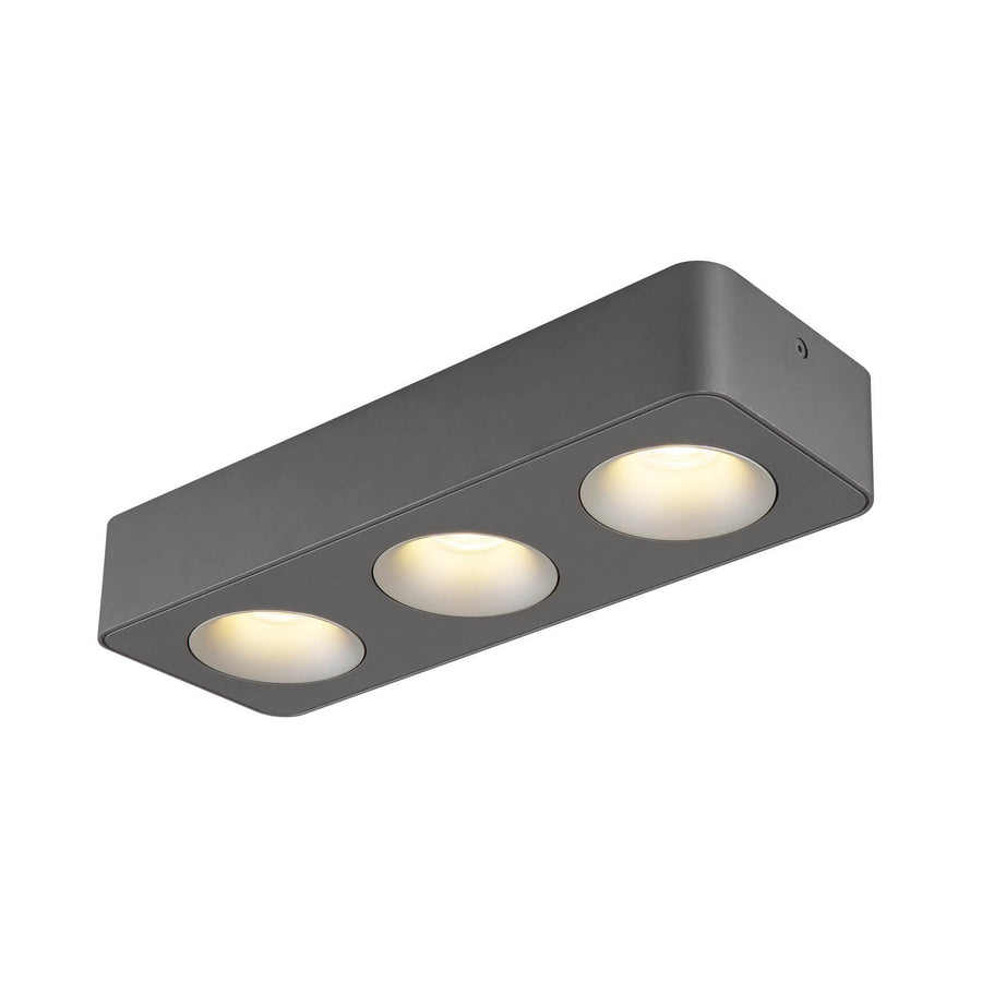 Spot rectangulaire gris à trois diffuseurs ronds allumés, vue de trois quarts