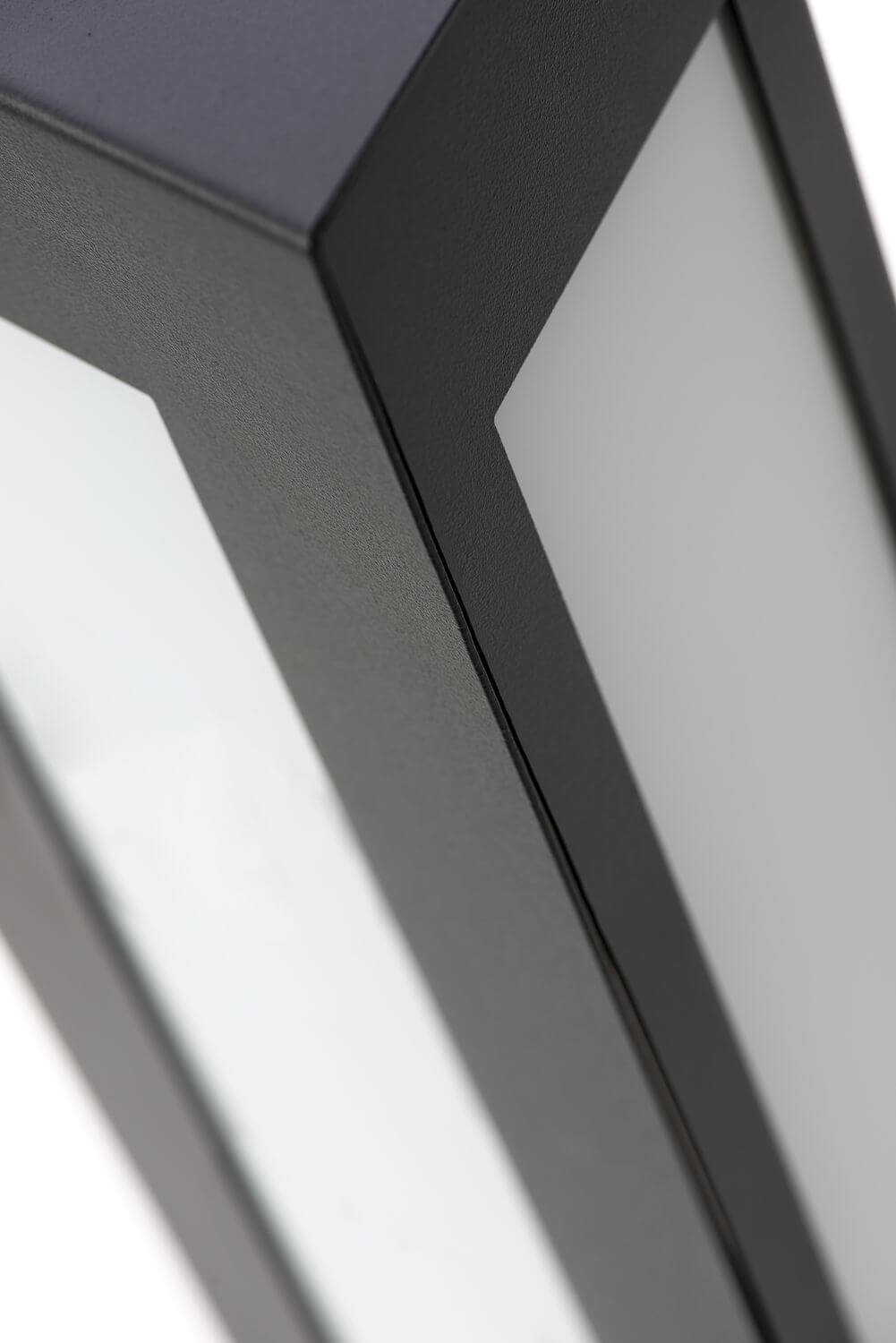 Détail rapproché d'un angle du cadre métallique et de la surface diffusante blanche.