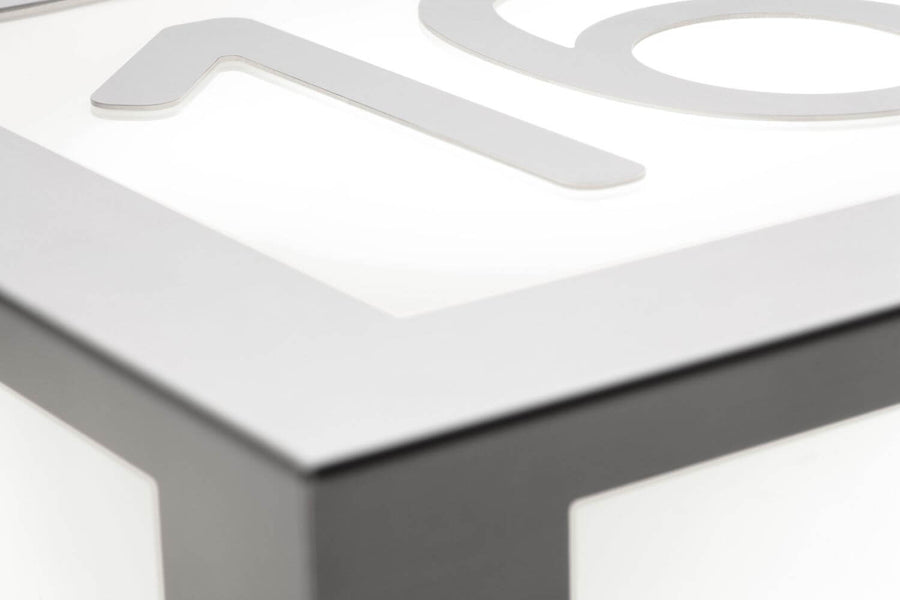 Détail du capot inox et des chiffres ajourés sur le diffuseur blanc