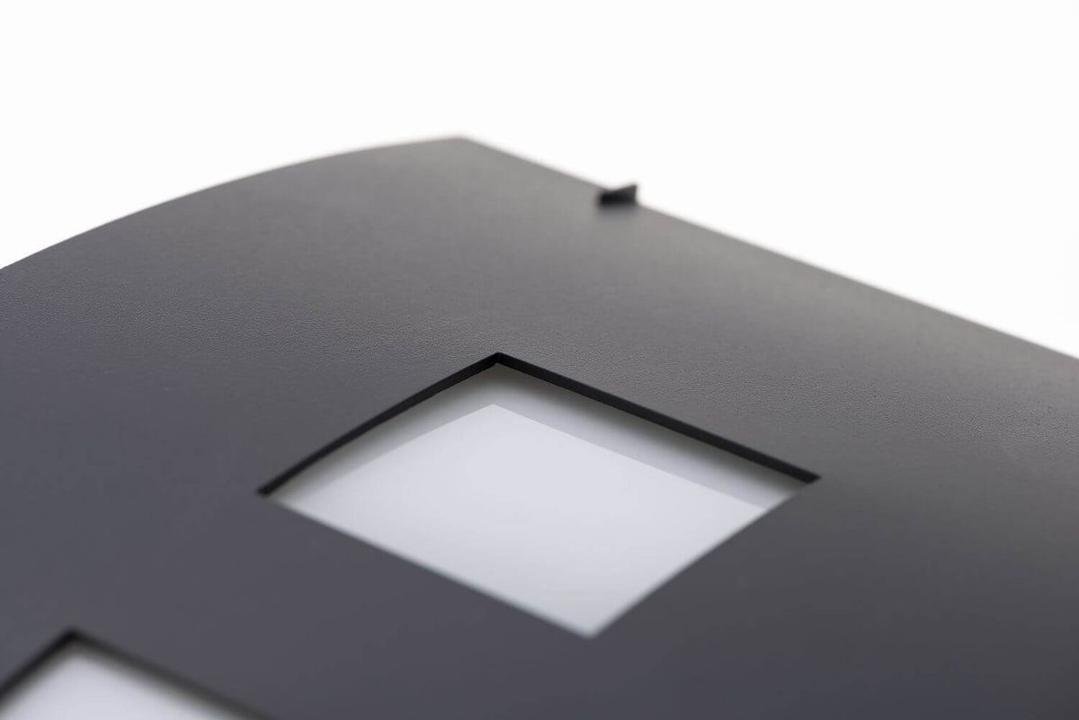 Détail de la finition granitée et d'une ouverture carrée au diffuseur blanc
