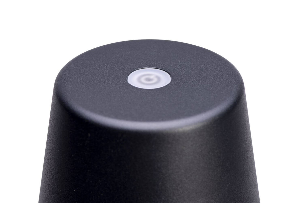 Détail du sommet de l'abat-jour noir avec bouton tactile central blanc.