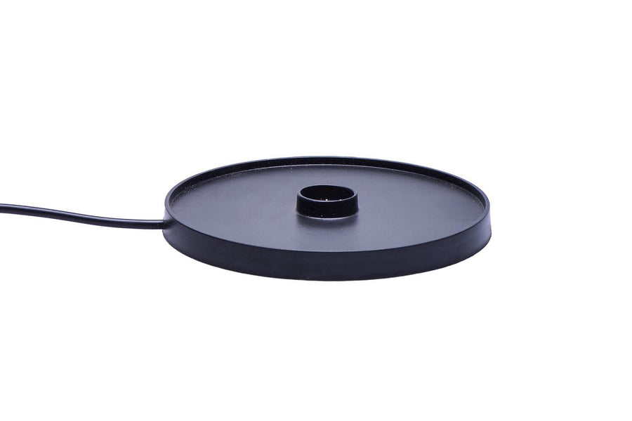 Gros plan sur la base de recharge noire ronde et son câble.