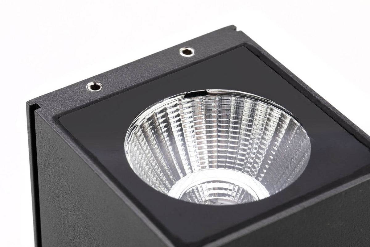 Détail rapproché de la lentille supérieure striée et des vis de fixation du luminaire.