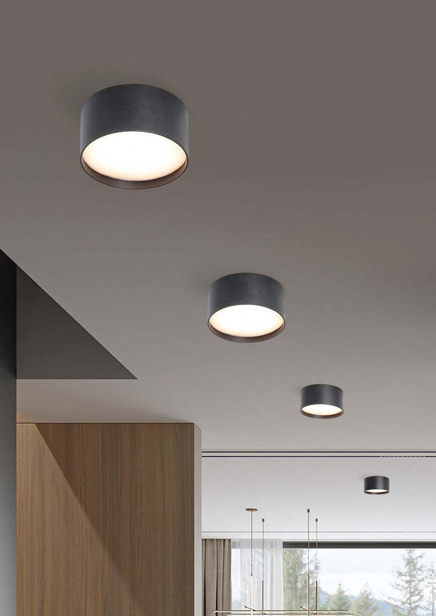 Mise en ambiance de plusieurs plafonniers noirs allumés sous un plafond intérieur