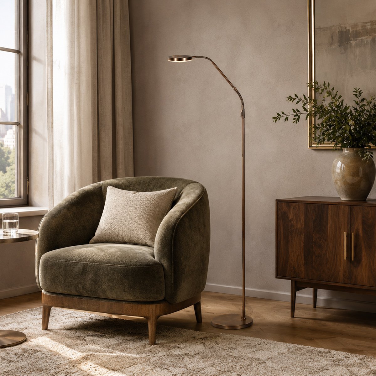 Lampadaire bronze dans un salon avec fauteuil vert, parquet et lumière naturelle.