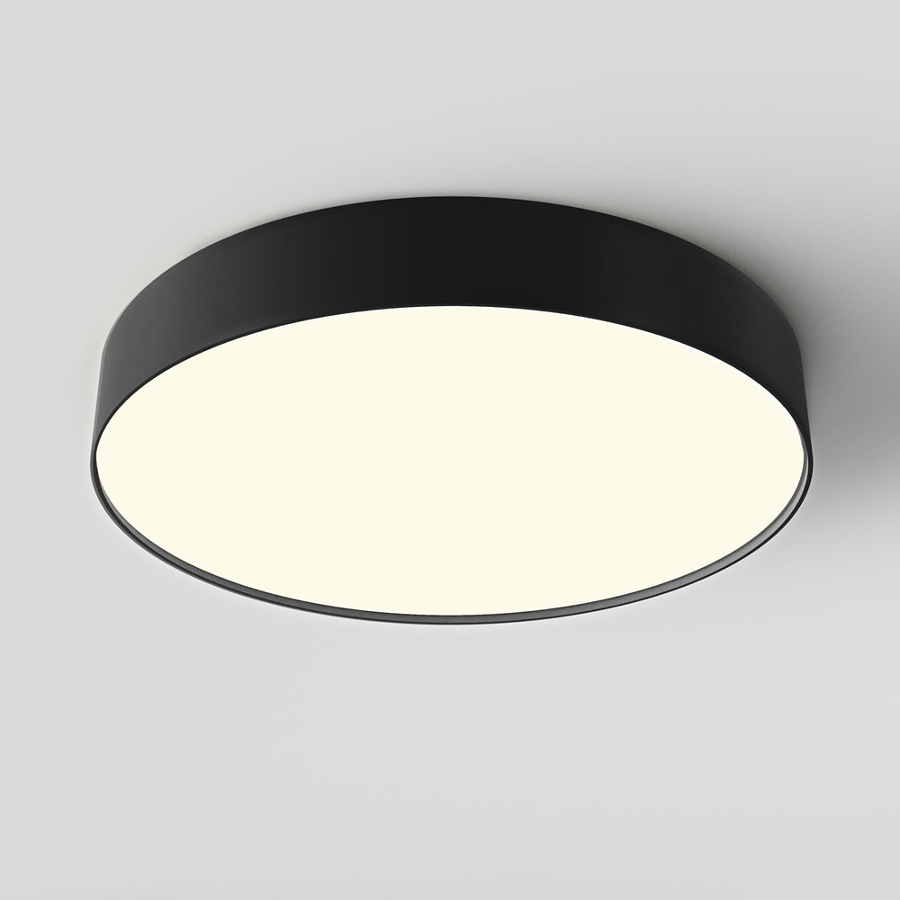 Plafonnier rond noir vu de dessous, diffusant une lumière blanche uniforme