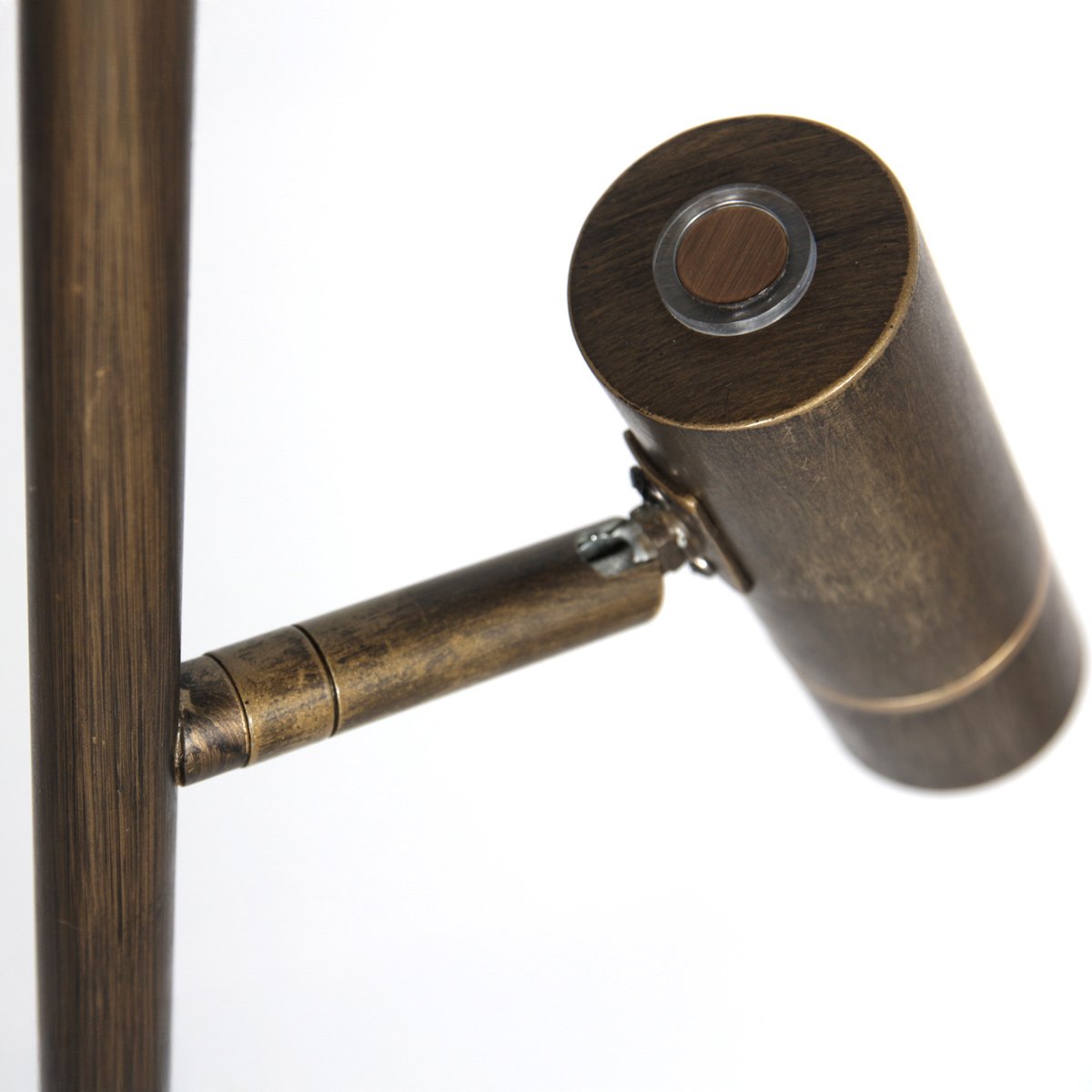Gros plan sur le projecteur cylindrique bronze orientable fixé sur le montant.