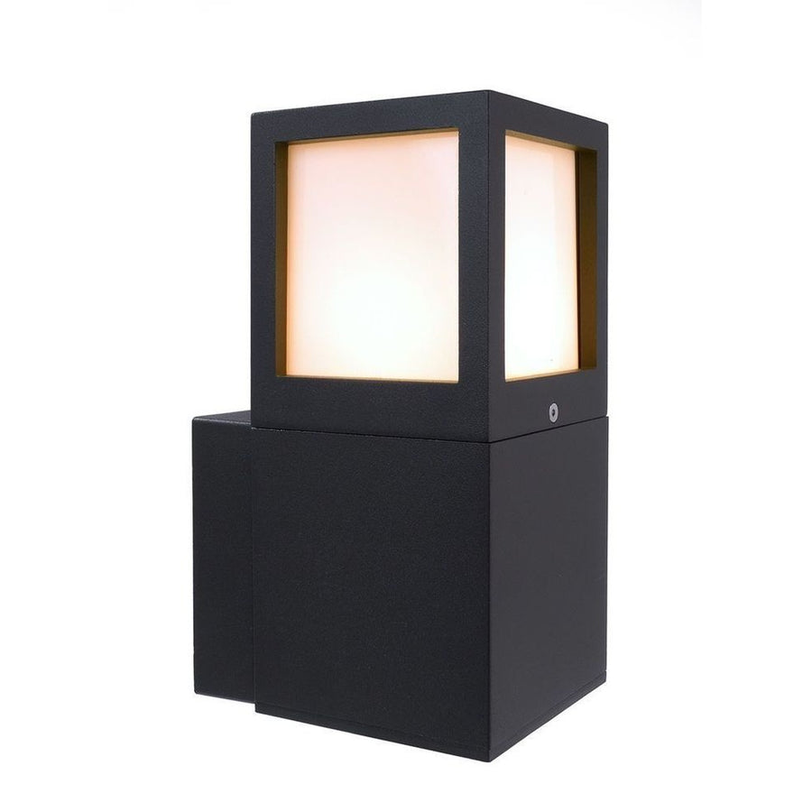 Vue de trois quarts du luminaire cubique anthracite allumé sur fond blanc