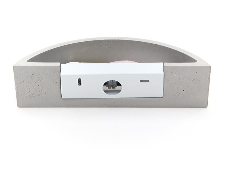 Détail du bloc électrique blanc fixé à l'arrière de l'applique en béton gris.
