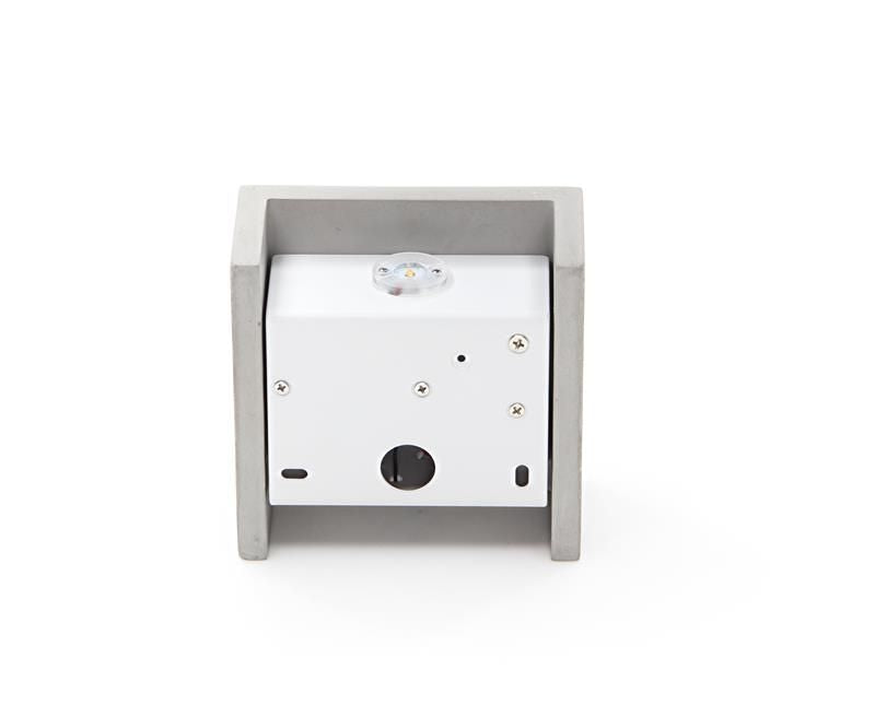 Détail arrière : module électrique blanc et visserie intégrés dans le cadre en béton.