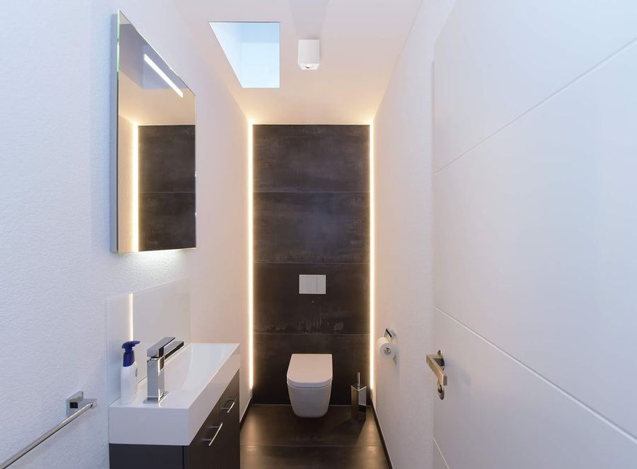 Mise en situation du spot blanc monté au plafond dans des toilettes modernes.