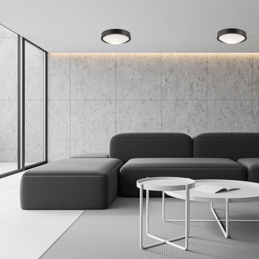 Deux plafonniers ronds noirs installés au plafond d’un salon gris contemporain.