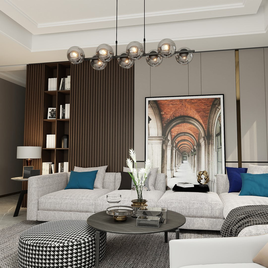 Vue large du séjour avec le luminaire suspendu allumé et son reflet sur le mobilier.