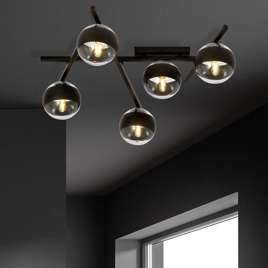 Mise en scène sur plafond sombre, cinq globes diffusant une lumière chaude