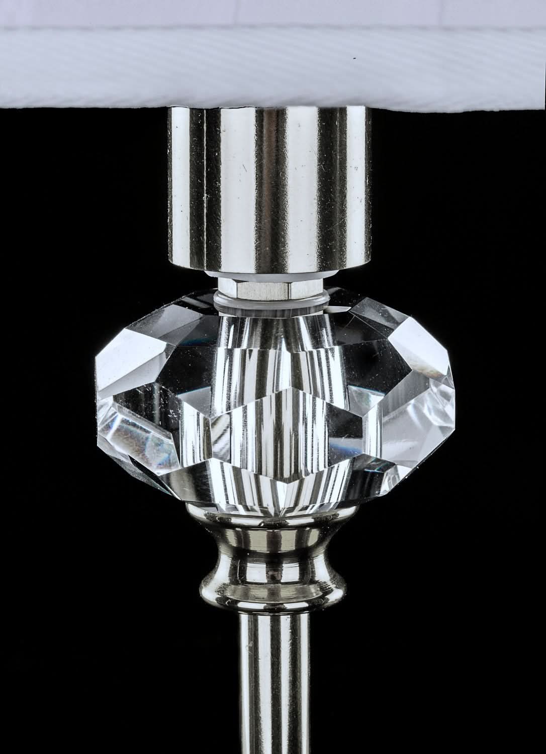 Gros plan sur la bague en cristal taillé reliant le pied à l'abat-jour.