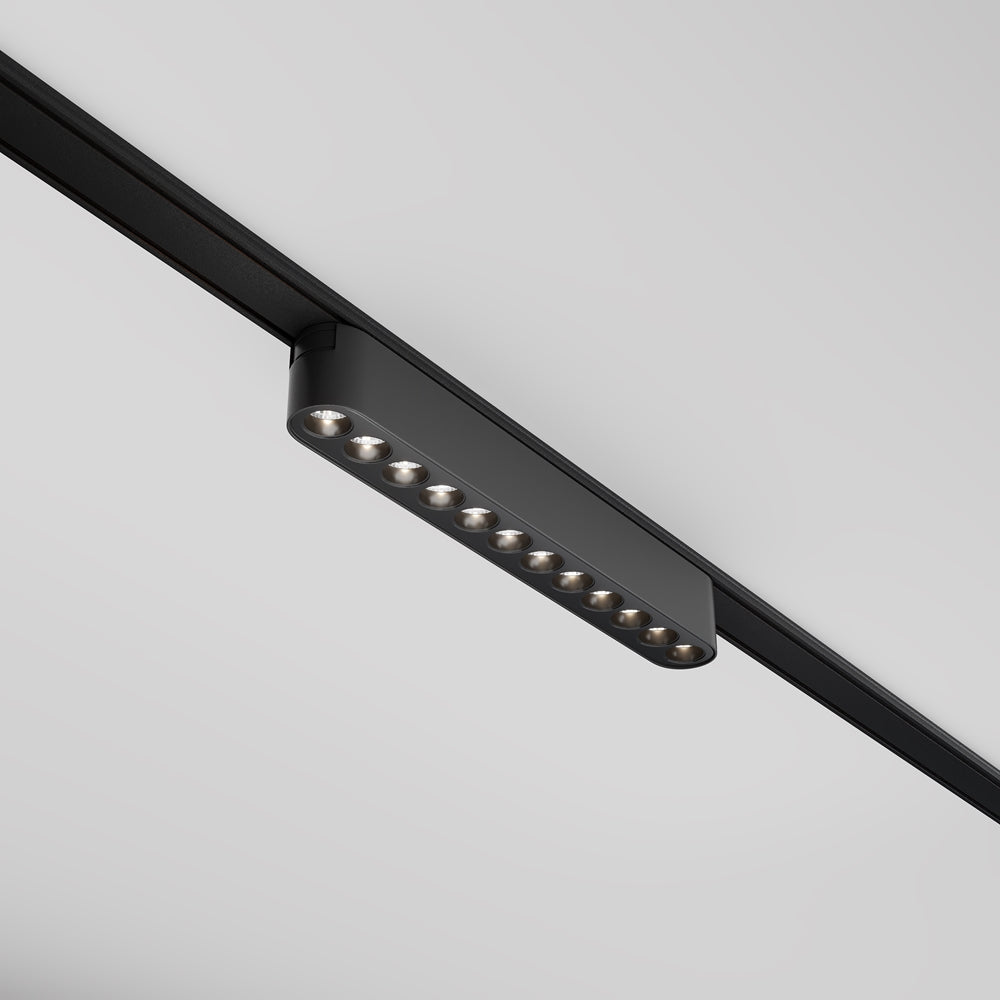 Luminaire noir allongé monté sur rail, série de spots LED alignés en dessous