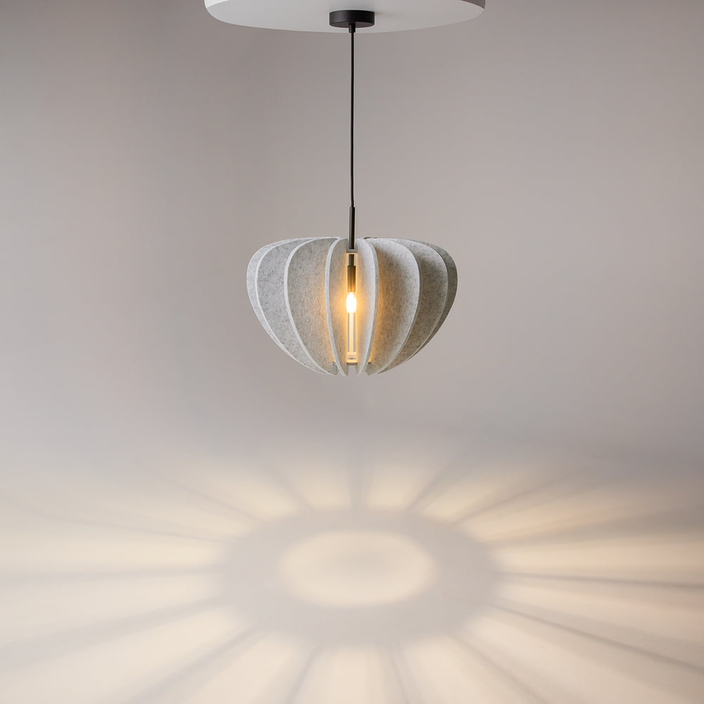 Luminaire allumé projetant des rayons en éventail sur le mur beige