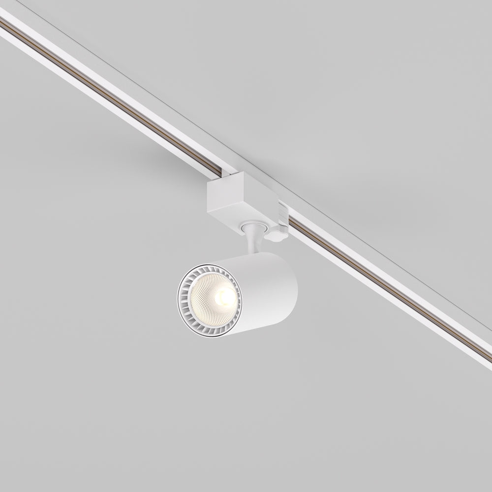 Spot blanc orientable fixé sur un rail de plafond, vu de trois quarts