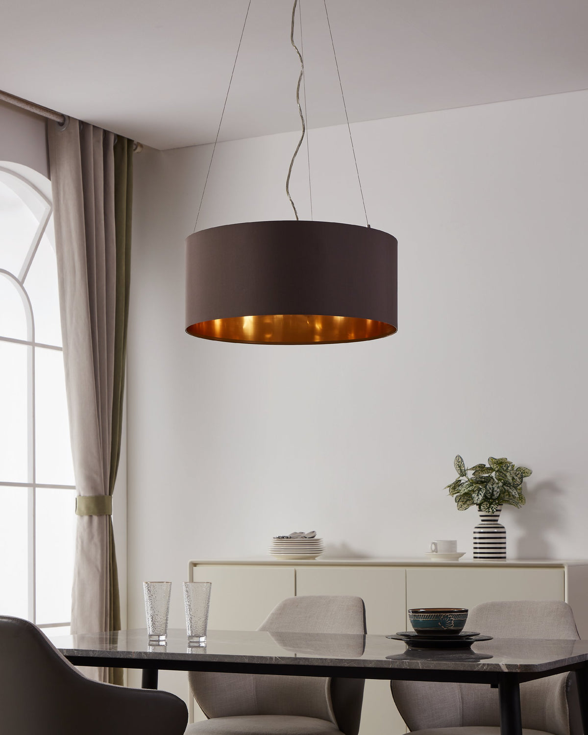 Luminaire allumé dans une salle à manger moderne, intérieur doré diffusant une lumière chaude