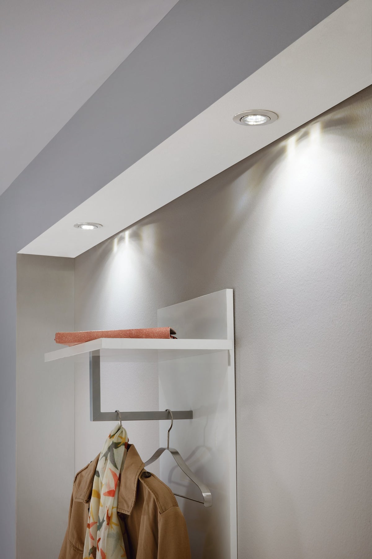 Application dans un dressing avec spots encastrés au plafond au-dessus d'une étagère et vêtements.