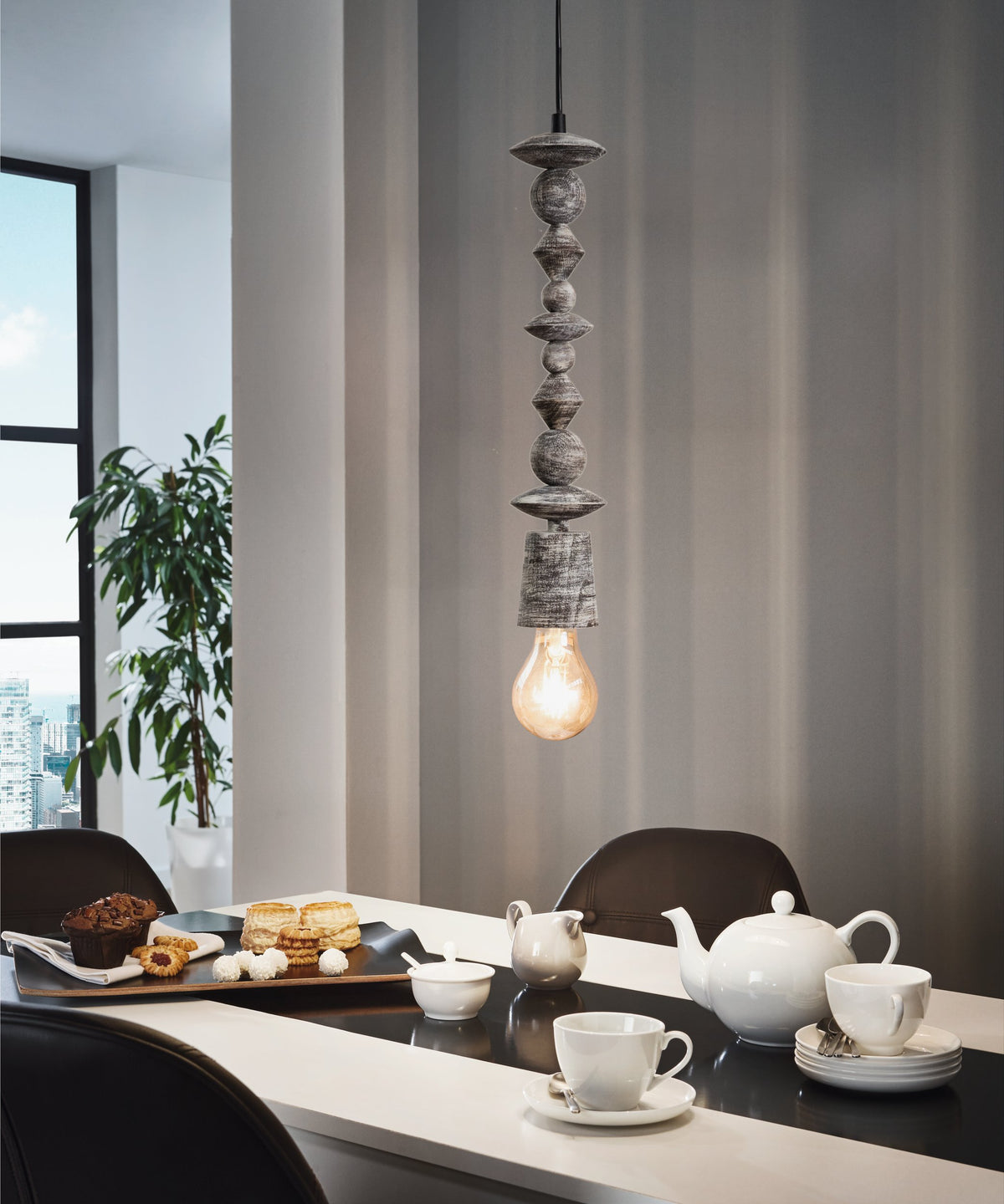 Mise en ambiance d'une salle à manger avec suspension allumée au-dessus d'une table dressée
