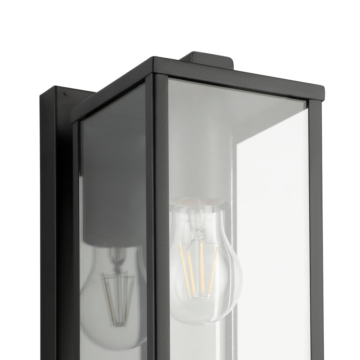Détail rapproché de l'angle du cadre noir et de l'ampoule à filament vue dans le verre