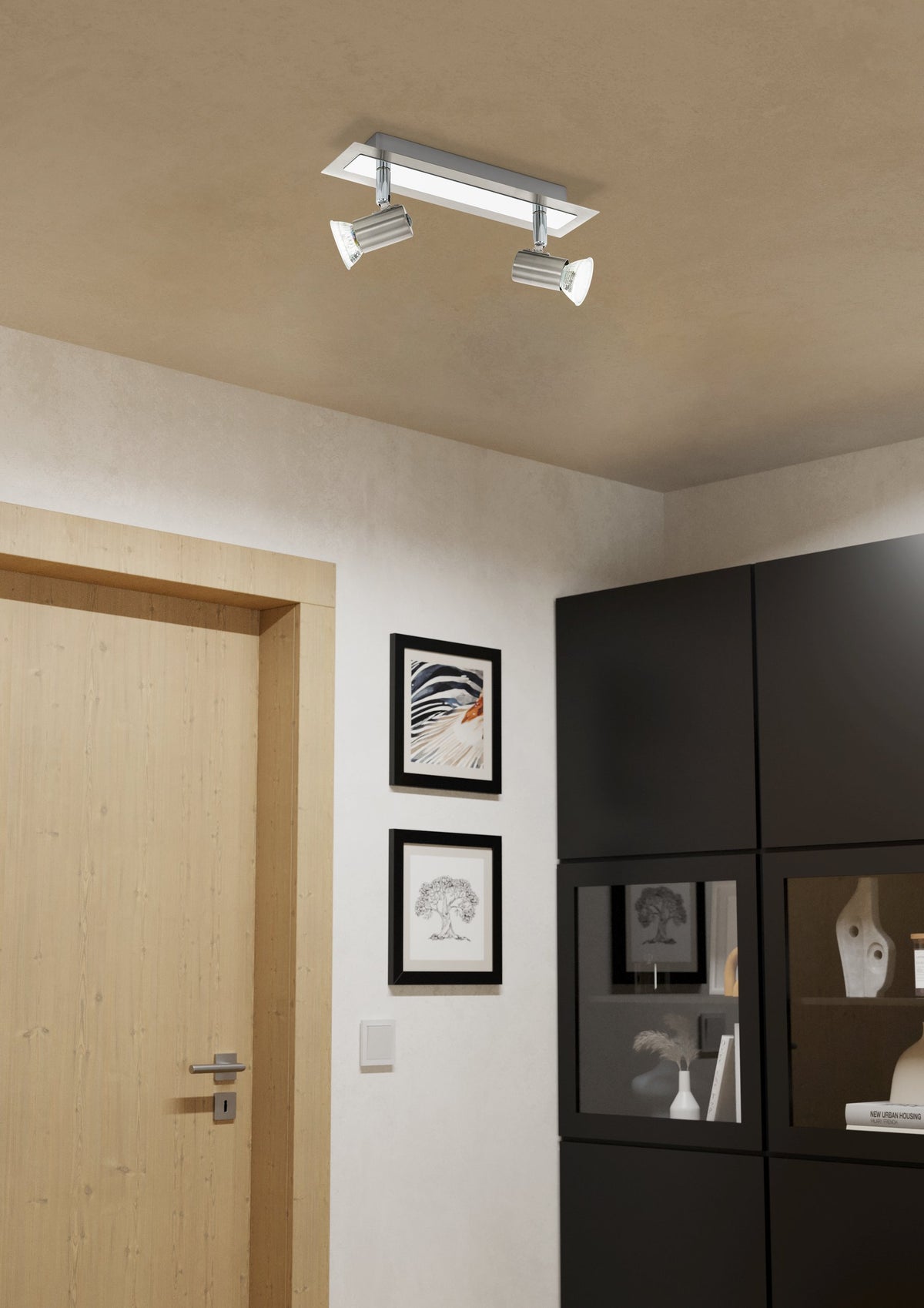 Mise en ambiance du luminaire plafond dans une entrée avec porte en bois et meuble noir.