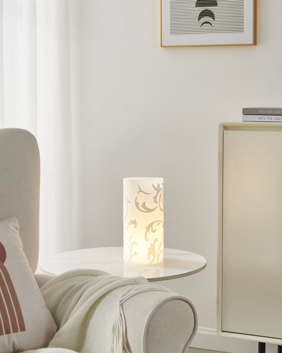 Lampe allumée posée sur table d'appoint dans un salon clair.