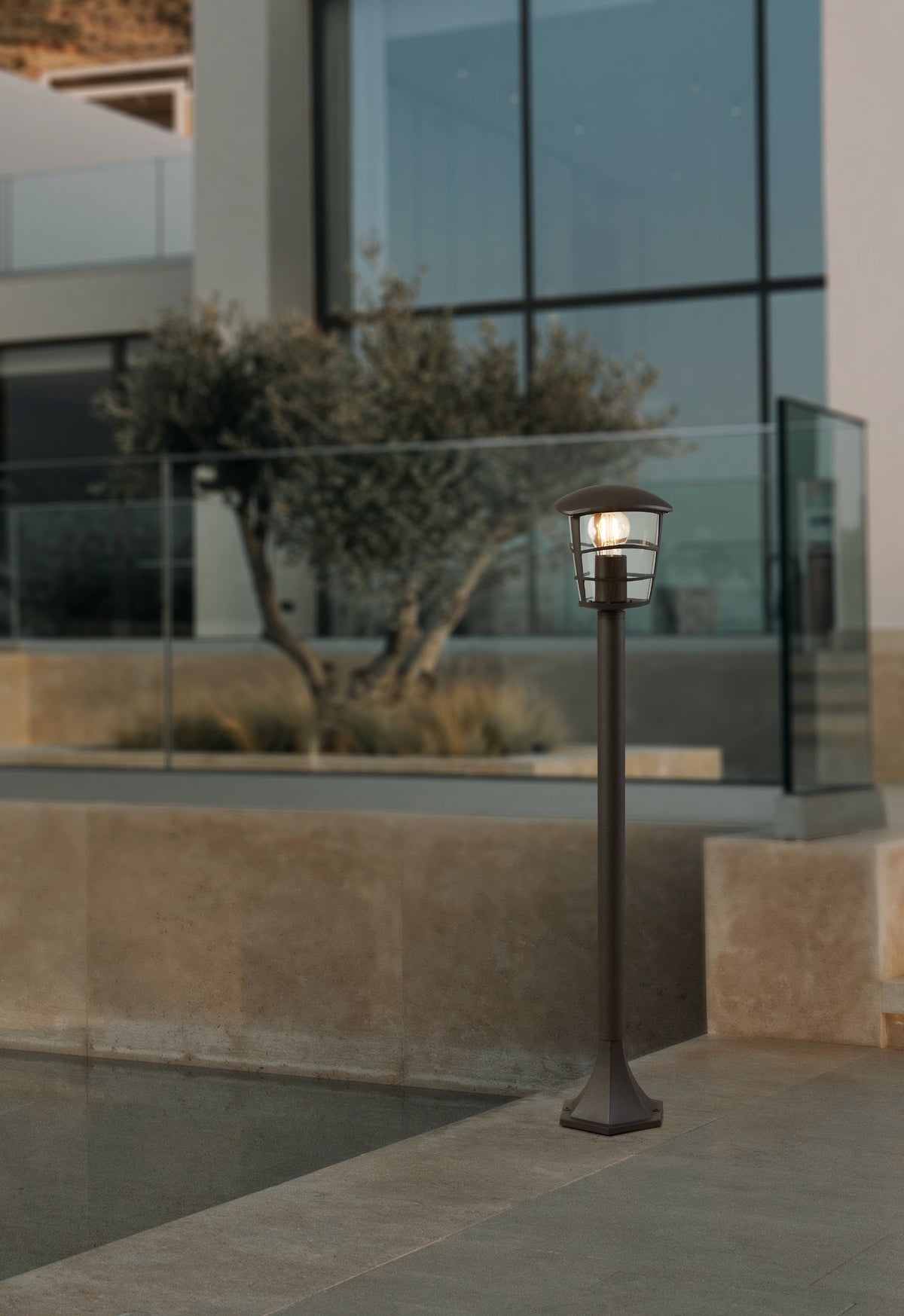 Mise en ambiance du lampadaire allumé au bord d'une terrasse en pierre