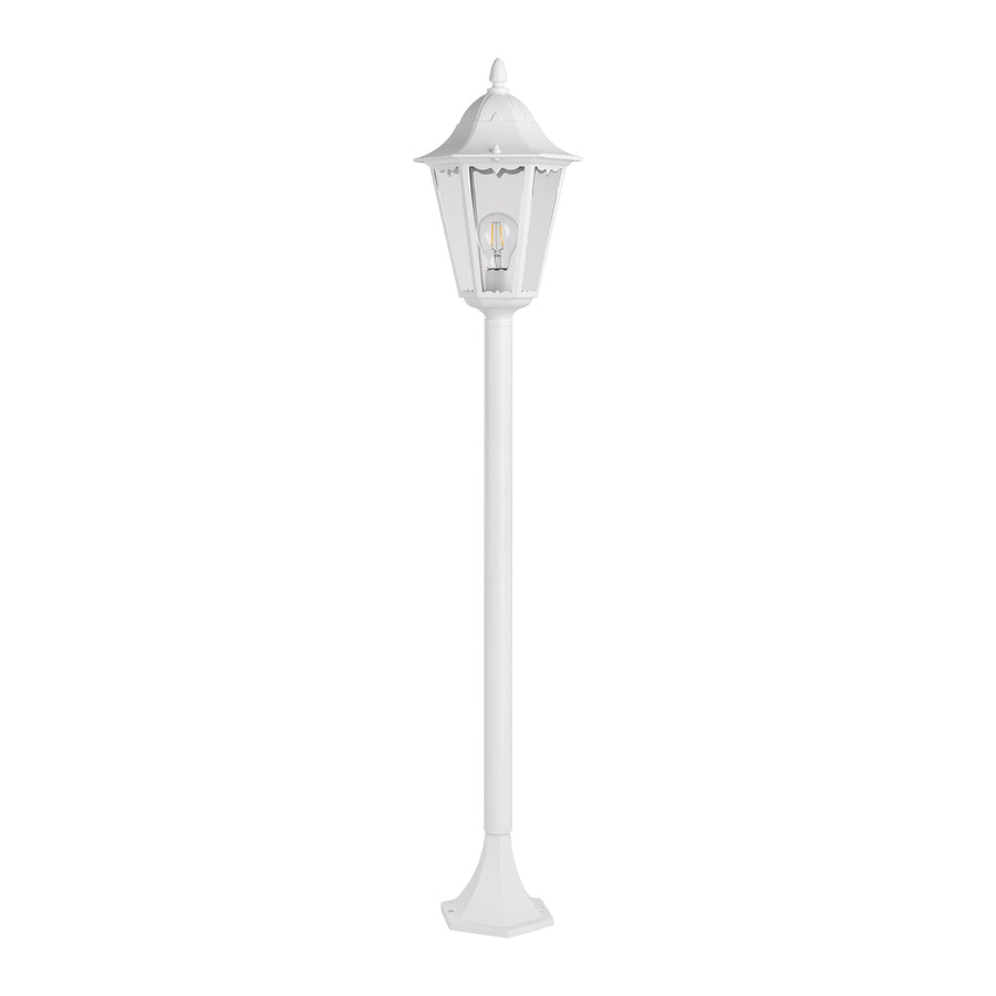 Vue de trois quarts du lampadaire blanc, ampoule allumée visible dans la lanterne vitrée.