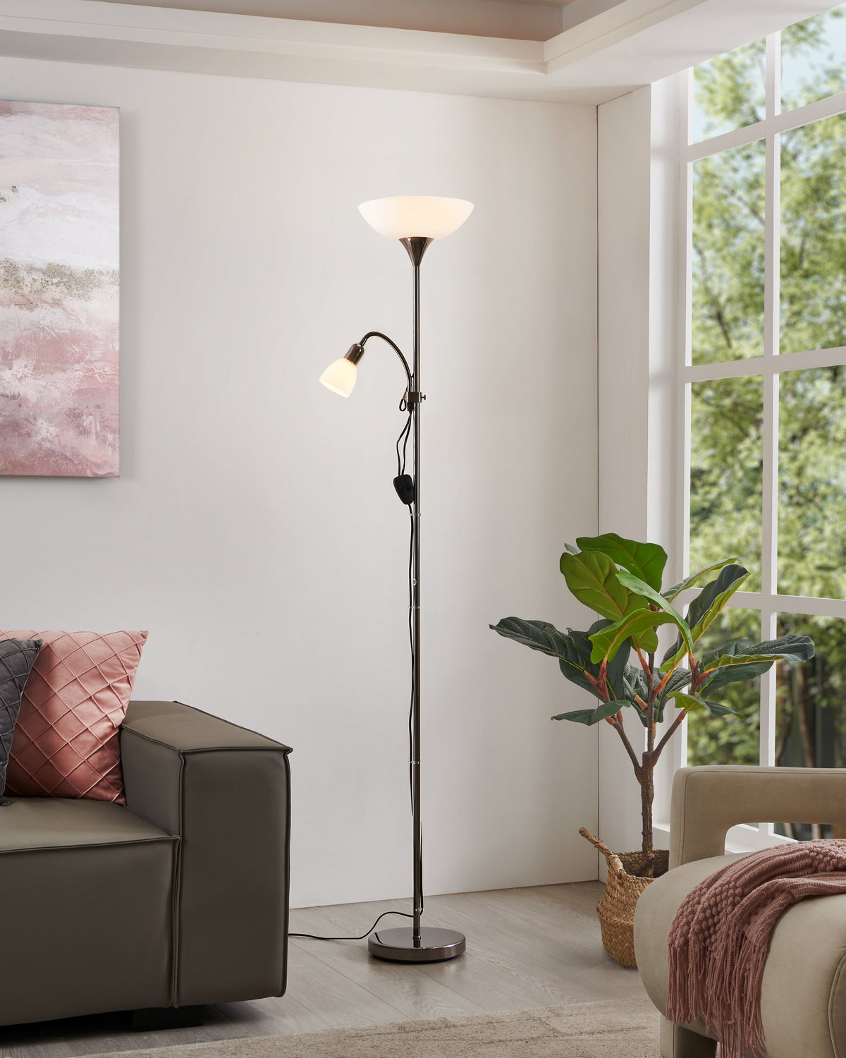 Lampadaire allumé dans un salon près d'un canapé et d'une grande fenêtre