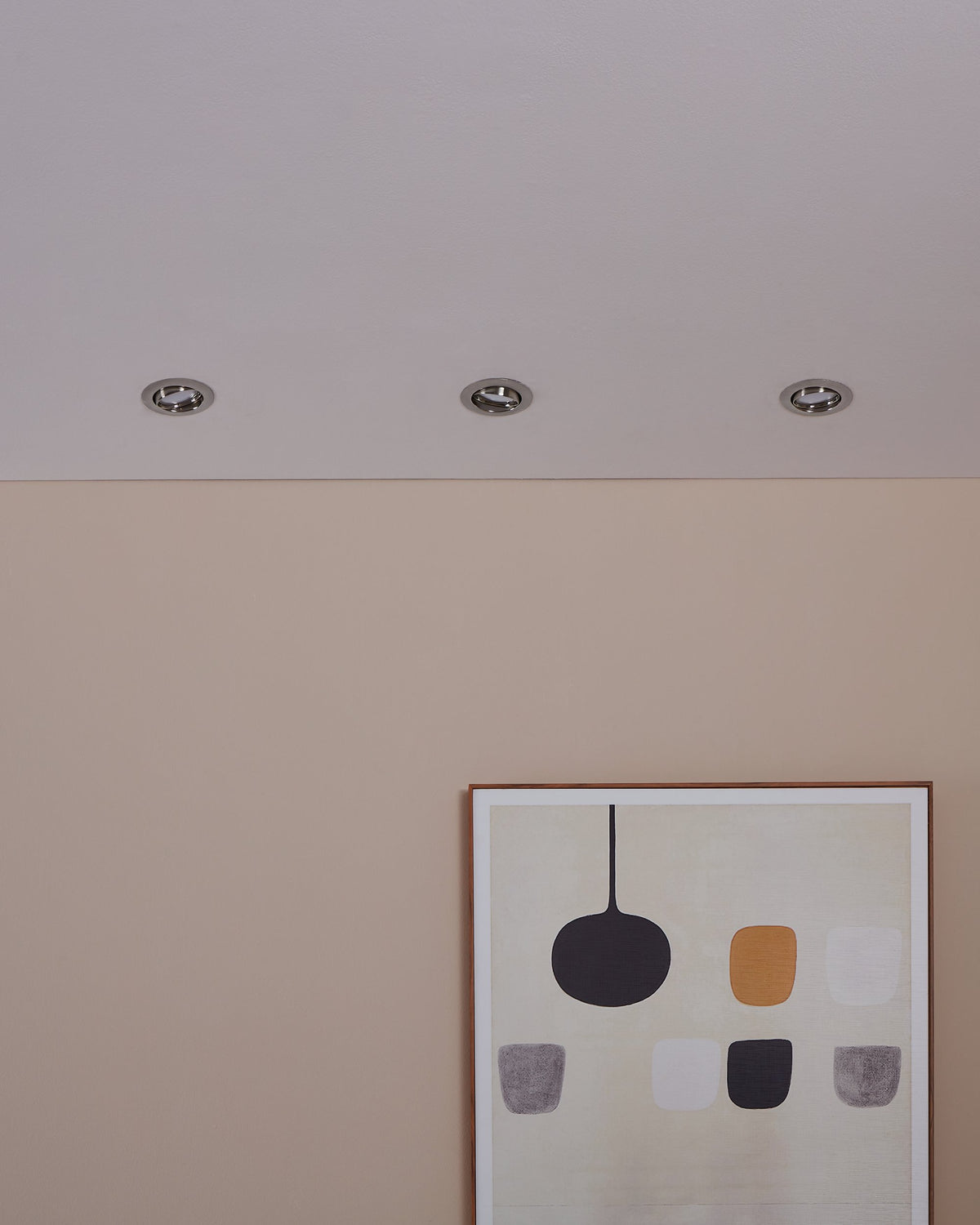 Plafond avec trois spots encastrés éteints au-dessus d'un tableau encadré