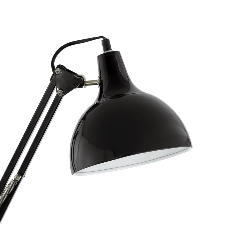 Gros plan sur l'abat-jour noir brillant et l'articulation métallique de la lampe.