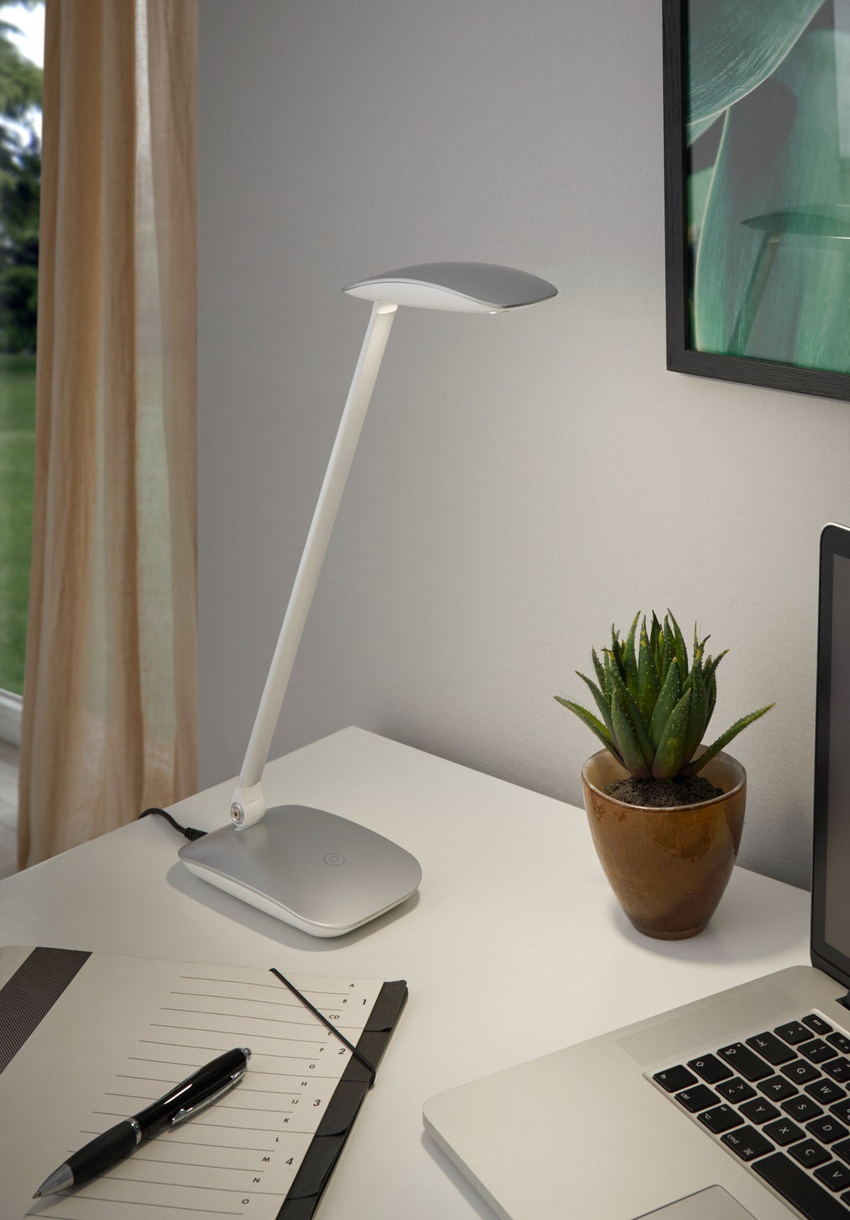 Mise en ambiance sur un bureau blanc avec carnet, stylo, ordinateur et plante