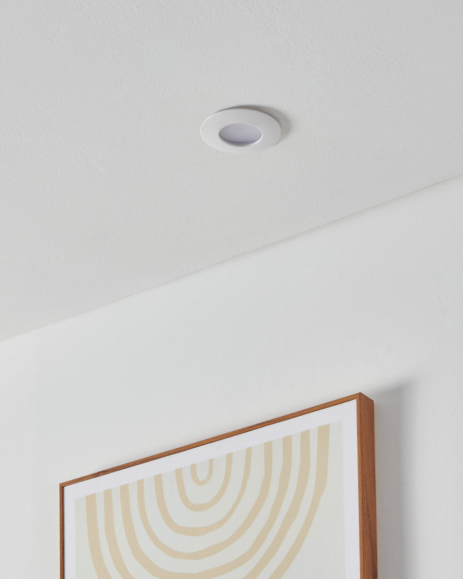 Spot encastré dans un plafond blanc, installé au-dessus d'un cadre en bois