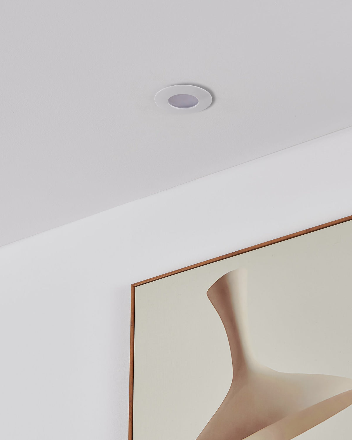 Spot encastré blanc allumé dans un plafond au-dessus d'un miroir