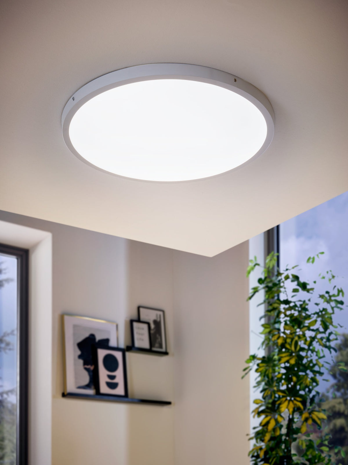 Mise en ambiance dans un salon moderne, plafonnier allumé au plafond blanc