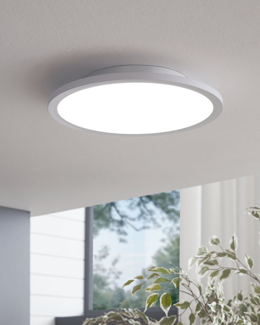 Plafonnier blanc installé au plafond dans un intérieur clair avec fenêtre et plantes