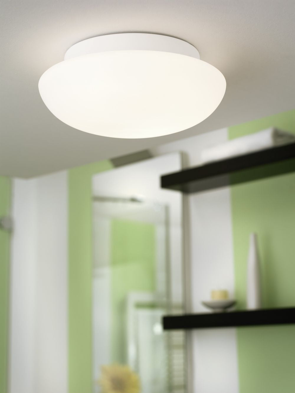 Mise en ambiance du plafonnier allumé dans une salle de bain aux murs verts