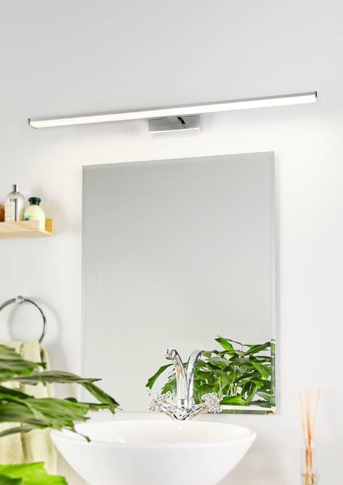 Applique allumée fixée au mur au-dessus d'un miroir de salle de bain