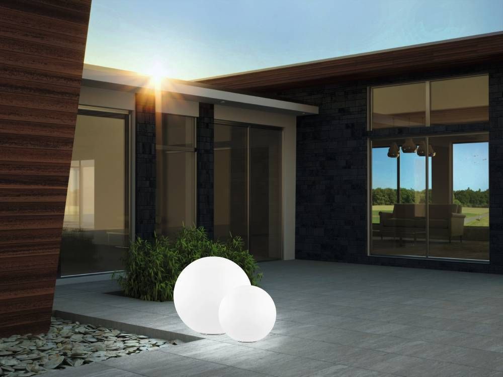 Scène de jour, deux globes blancs installés sur une terrasse en dalles grises