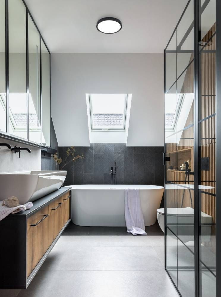 Mise en ambiance dans une salle de bain moderne avec baignoire et verrière