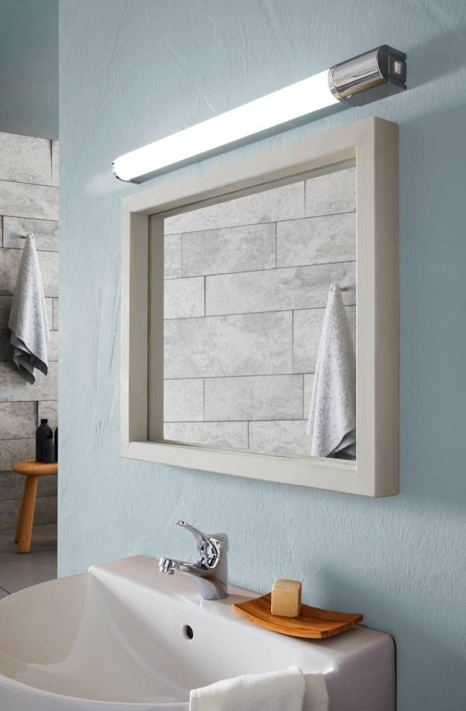 Autre vue de la même salle de bain, mettant en valeur le luminaire au-dessus du miroir.