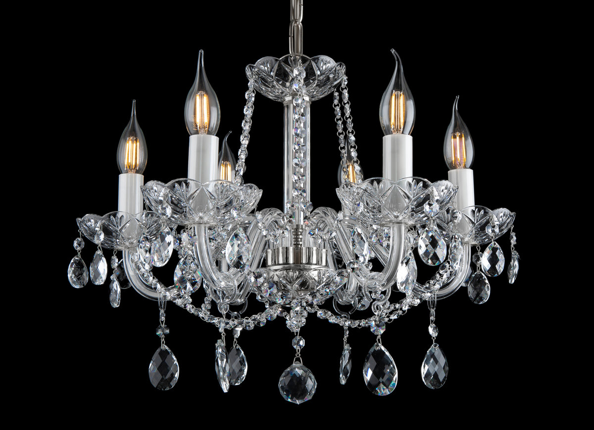 Lustre en cristal à cinq bras, ampoules flamme, pampilles goutte, vue de face sur fond noir.