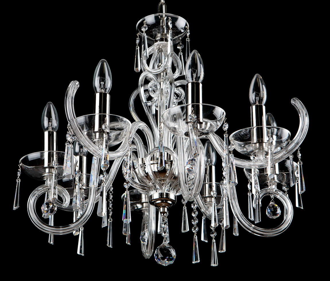Lustre cristal complet à bras recourbés et pendeloques, fond noir.