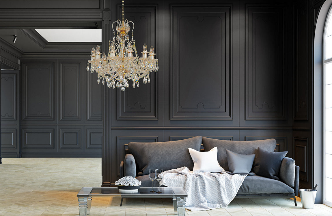 Lustre suspendu dans un salon sombre, canapé gris et moulures murales.