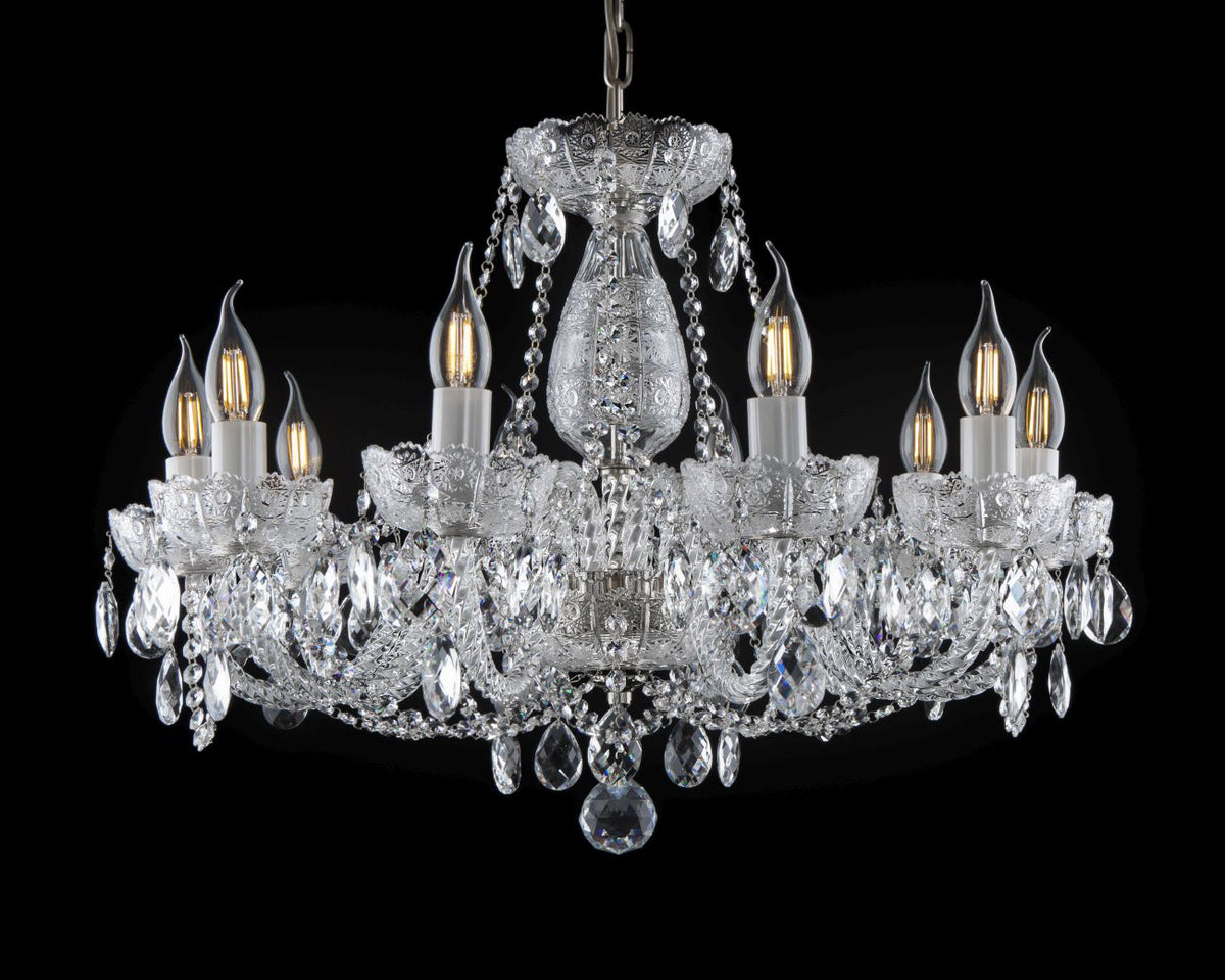 Vue d'ensemble du lustre, bras éclairés et guirlandes de cristal, fond noir