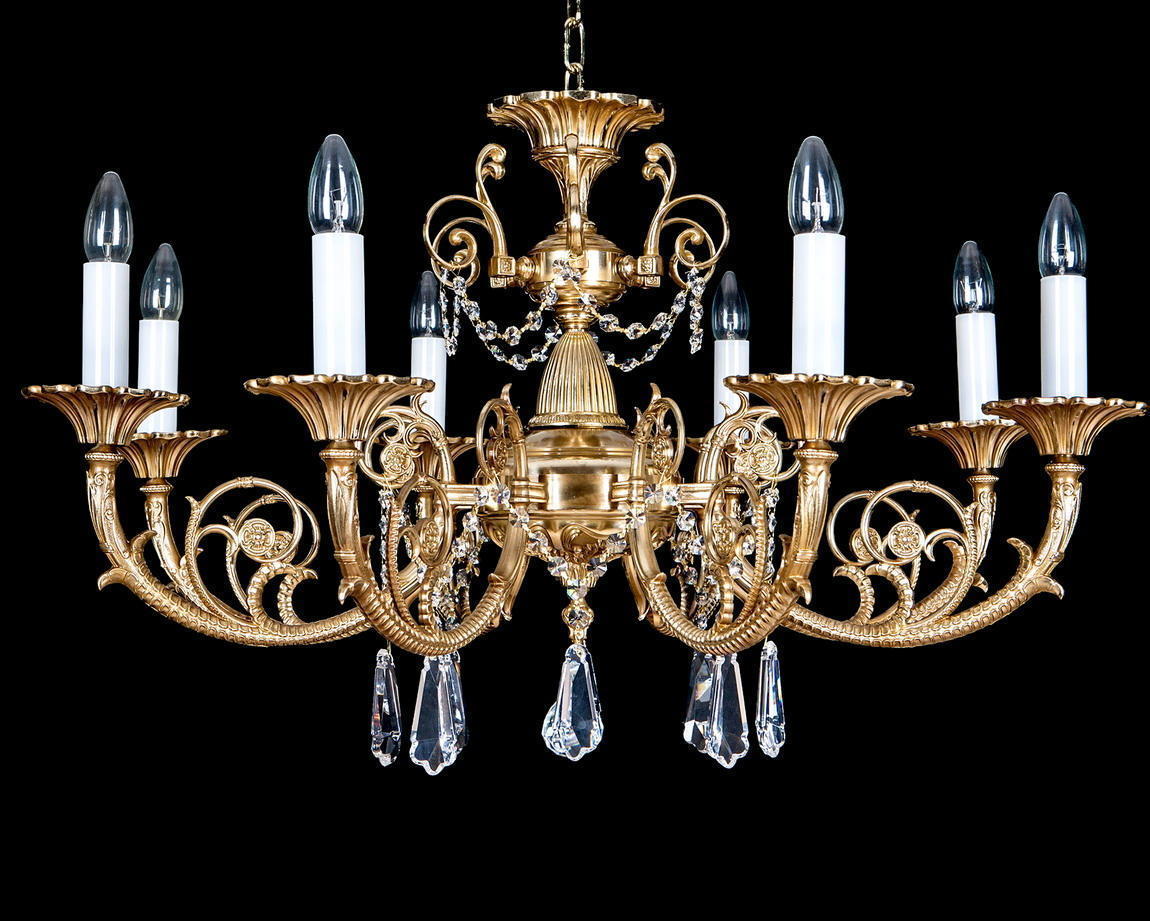 Lustre doré complet de face, douze bras chargés de pendentifs en cristal sur fond noir.
